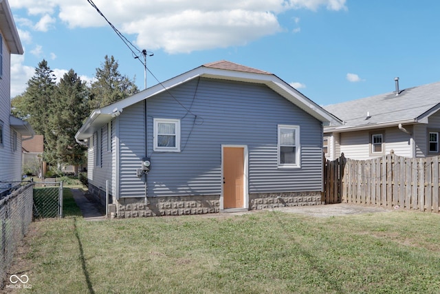 back of house featuring a lawn and a fenced backyard