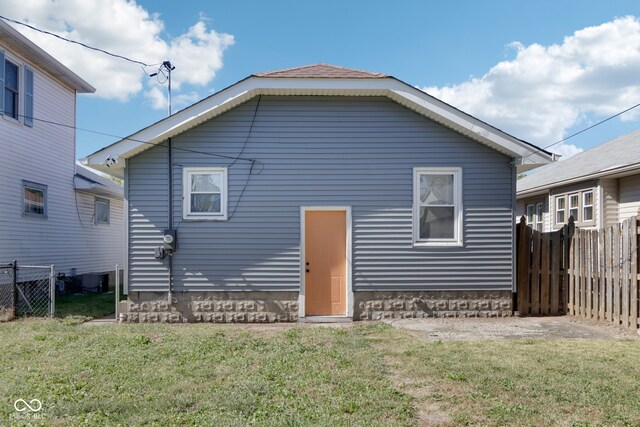 rear view of house featuring a yard