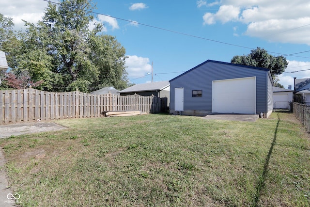 view of yard featuring a fenced backyard, an outdoor structure, and a garage