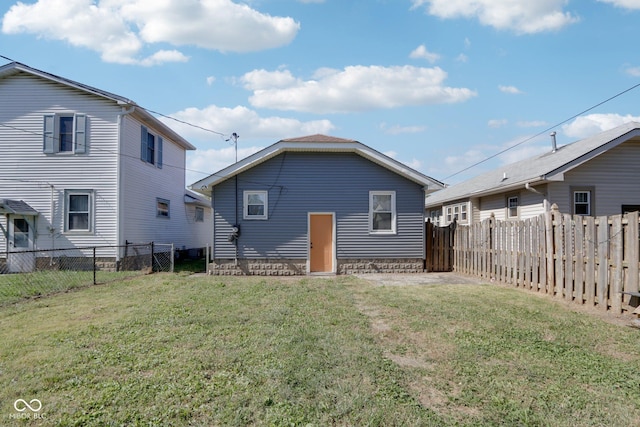 back of house featuring a yard and a fenced backyard