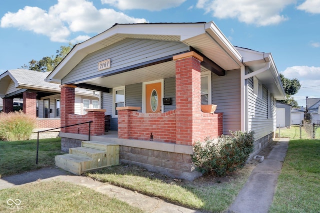 bungalow with a porch and brick siding
