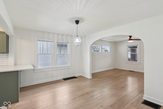 unfurnished dining area with ceiling fan, light hardwood / wood-style flooring, and a healthy amount of sunlight