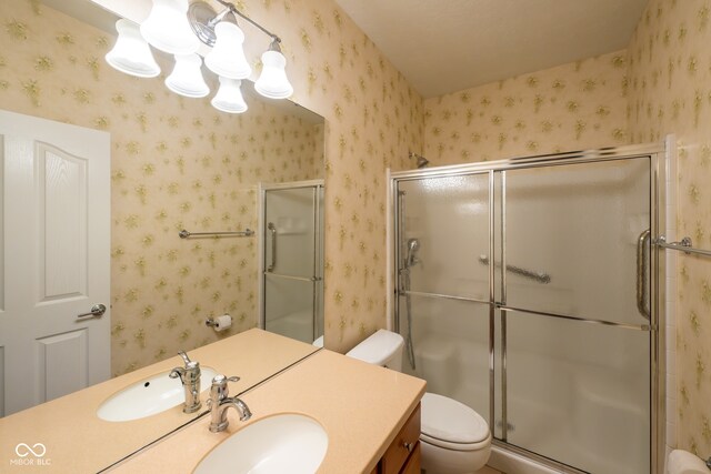 bathroom with vanity, toilet, and a shower with door