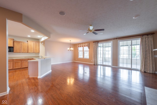 interior space featuring a textured ceiling, plenty of natural light, ceiling fan with notable chandelier, and sink