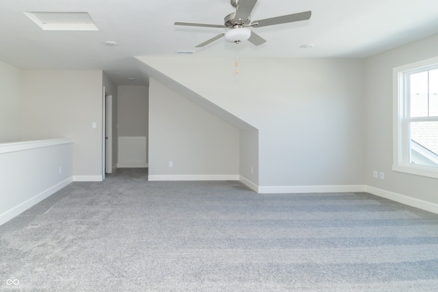 additional living space featuring ceiling fan and light colored carpet