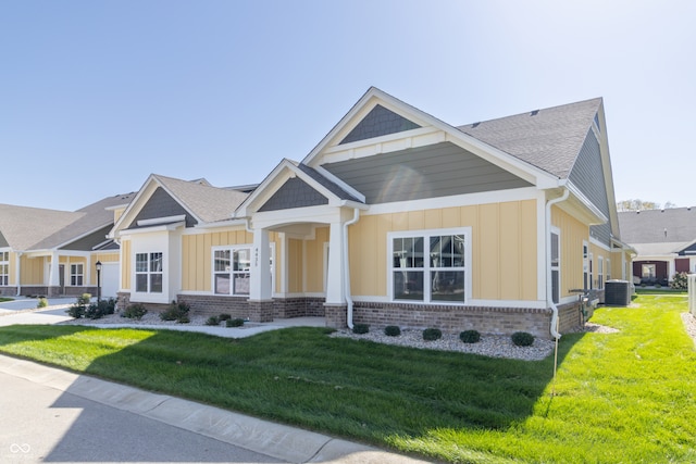 craftsman inspired home featuring a front lawn and central AC unit