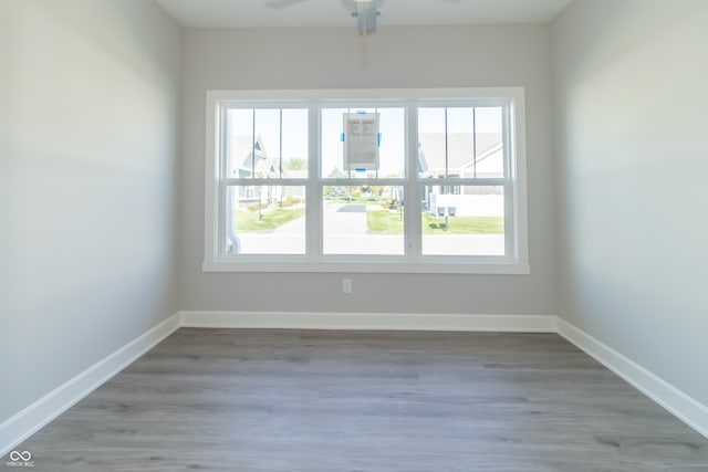 spare room with ceiling fan and light wood-type flooring