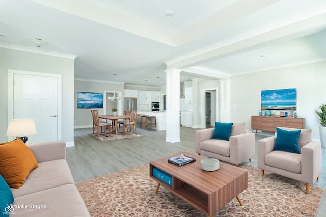 living room featuring ornate columns, crown molding, and light hardwood / wood-style floors