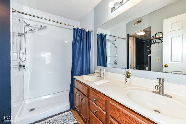 bathroom with visible vents, a sink, and a shower with shower curtain