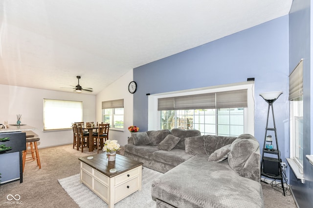 living room featuring lofted ceiling, a ceiling fan, and light carpet