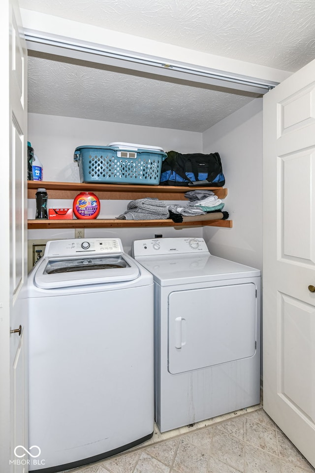 laundry room with washer and dryer, a textured ceiling, and laundry area
