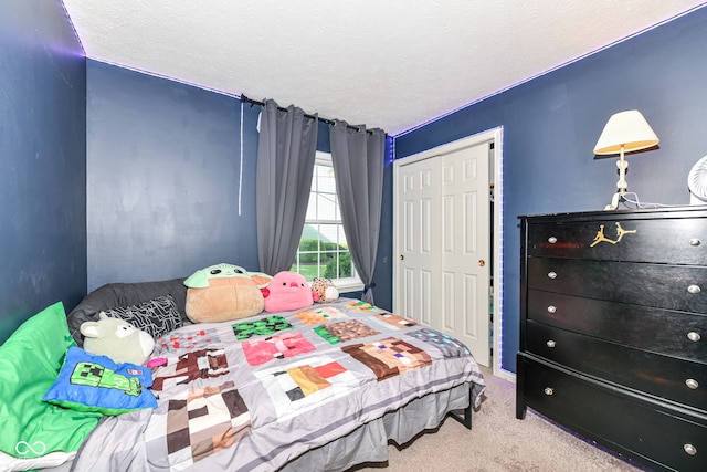 bedroom with a closet, carpet flooring, and a textured ceiling