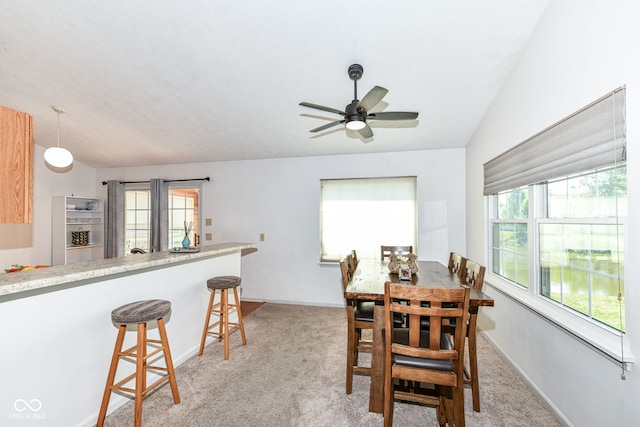 dining area featuring a ceiling fan, light colored carpet, and baseboards