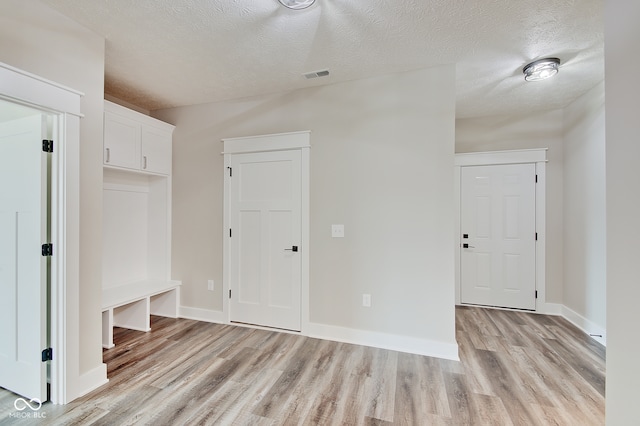 mudroom featuring a textured ceiling and light hardwood / wood-style flooring