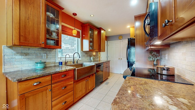 kitchen featuring sink, light stone counters, light tile patterned floors, pendant lighting, and black appliances