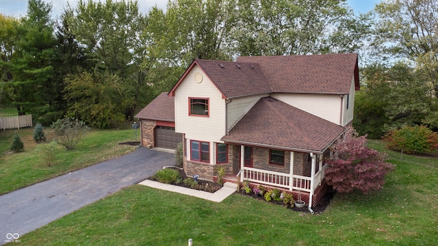 view of front facade with a garage, a front lawn, and a porch