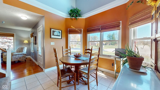 dining area featuring crown molding, a healthy amount of sunlight, and light tile patterned flooring