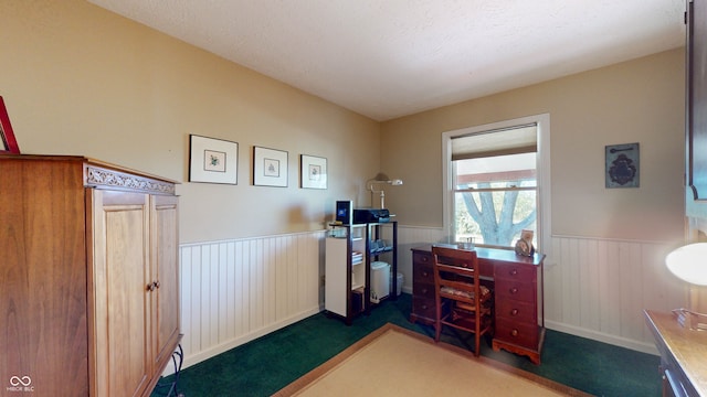 carpeted office space featuring a textured ceiling