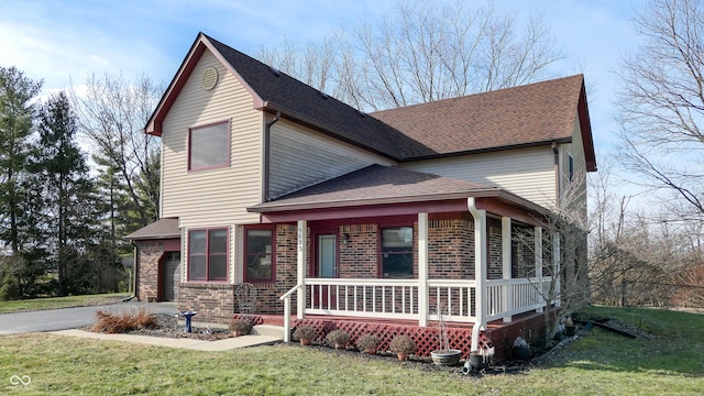 view of front of house with a porch, a garage, and a front yard