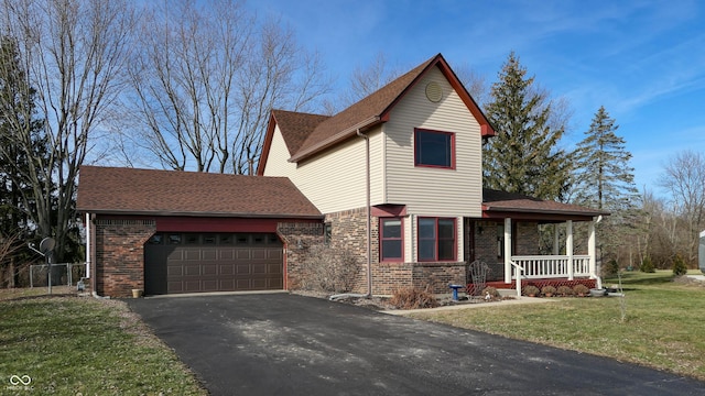 view of front property with a garage, a front yard, and covered porch