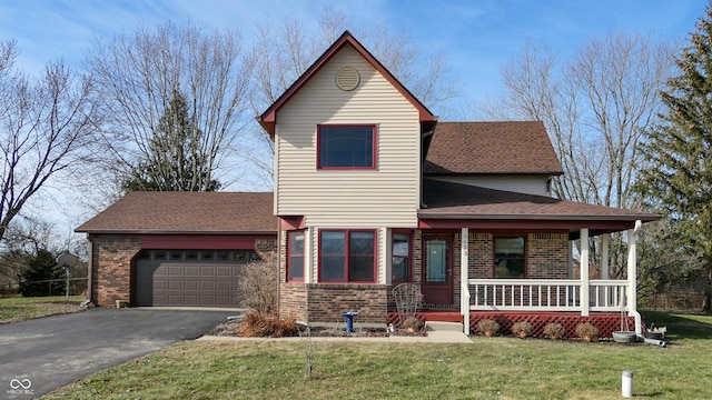 view of front property featuring a garage, covered porch, and a front yard