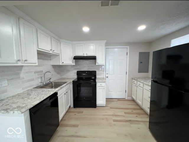 kitchen with white cabinets, electric panel, sink, black appliances, and light hardwood / wood-style floors