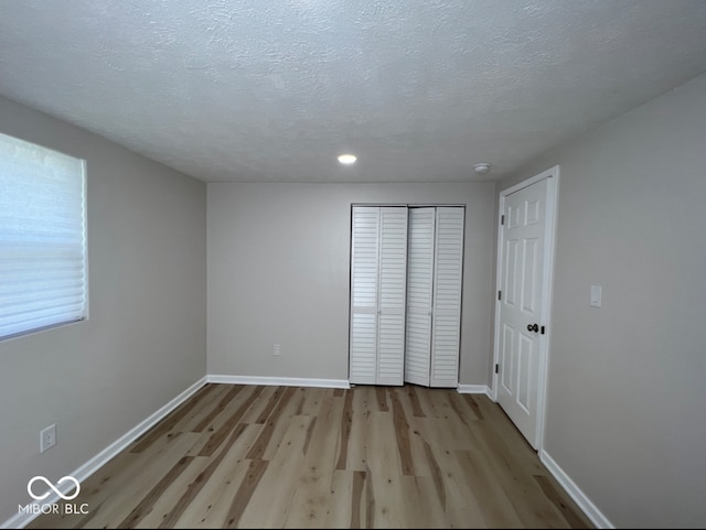 unfurnished bedroom featuring light hardwood / wood-style floors and a textured ceiling