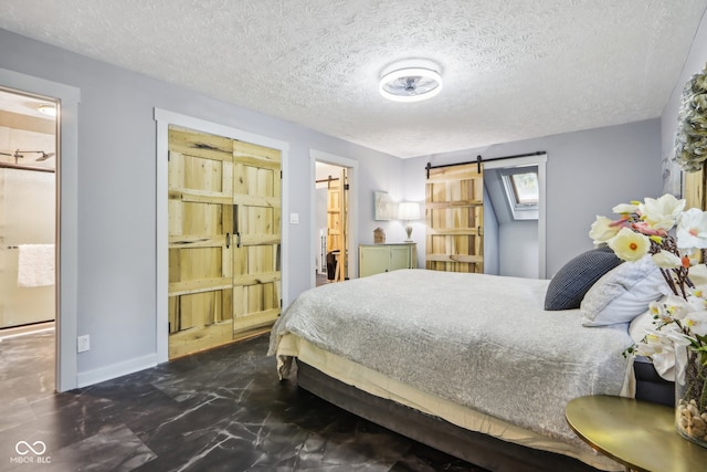 bedroom with connected bathroom, a barn door, and a textured ceiling