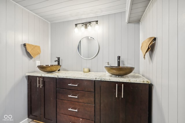 bathroom with vanity and wood walls