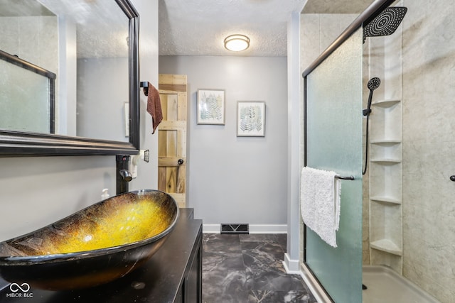 bathroom featuring vanity, a textured ceiling, and walk in shower