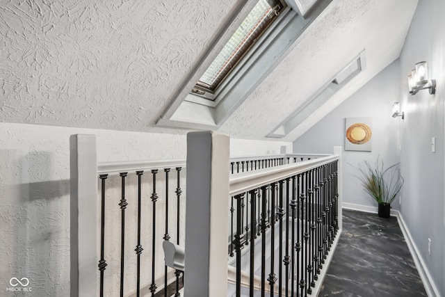 corridor featuring vaulted ceiling with skylight