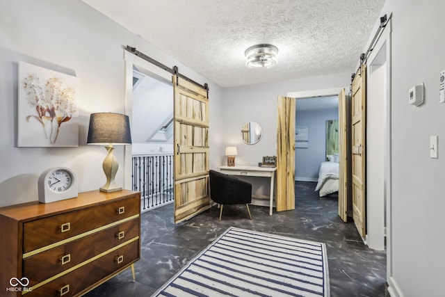 interior space with a barn door and a textured ceiling