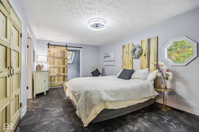 bedroom with a textured ceiling and a barn door