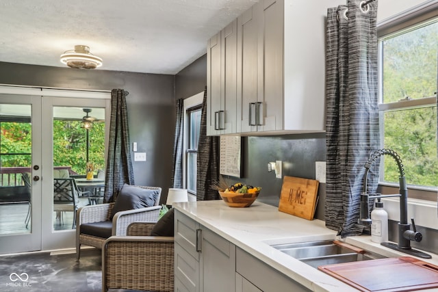 kitchen featuring gray cabinetry, a healthy amount of sunlight, french doors, and sink