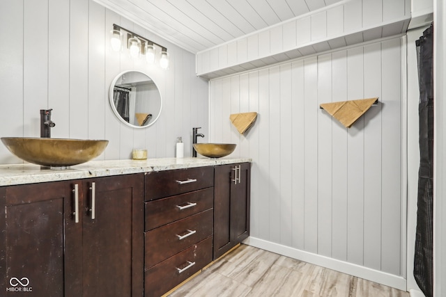 bathroom featuring vanity, wooden walls, and hardwood / wood-style flooring