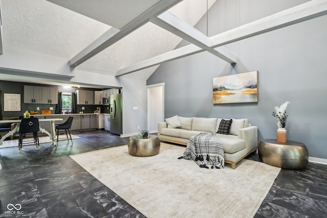 living room featuring lofted ceiling with beams and a textured ceiling