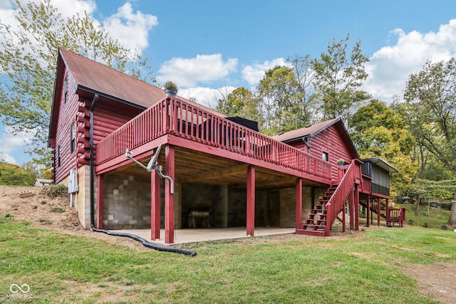 rear view of property featuring a yard, a wooden deck, and a patio