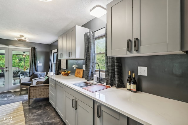 kitchen with french doors, dark wood-type flooring, gray cabinetry, sink, and a textured ceiling