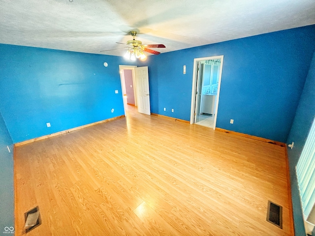 spare room with light hardwood / wood-style flooring, a textured ceiling, and ceiling fan