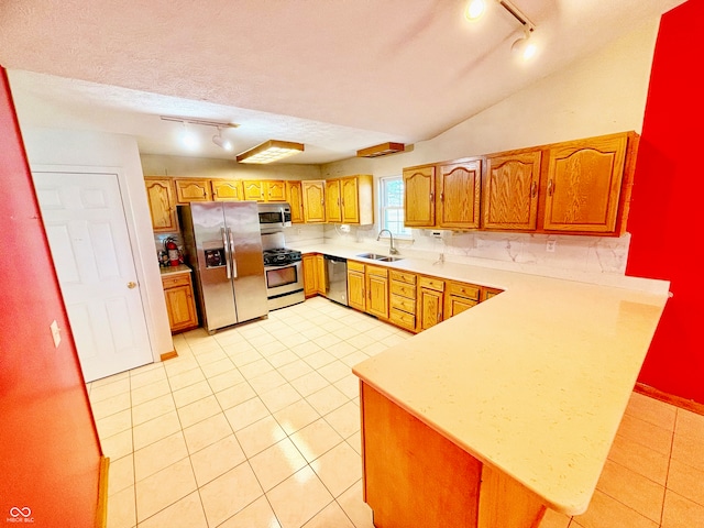 kitchen featuring appliances with stainless steel finishes, kitchen peninsula, sink, and track lighting