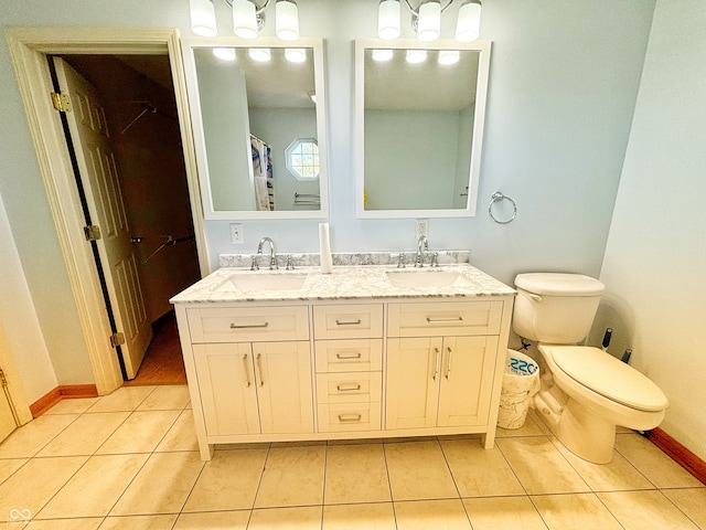 bathroom with toilet, vanity, and tile patterned floors