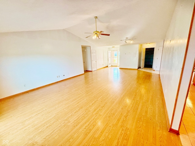 spare room featuring light hardwood / wood-style floors, vaulted ceiling, and ceiling fan