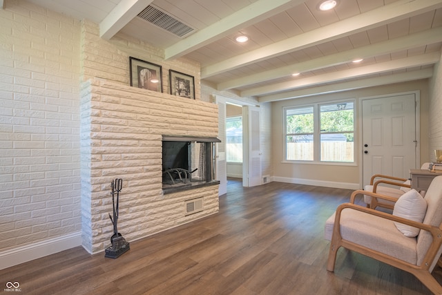 sitting room with beam ceiling, dark hardwood / wood-style flooring, and a multi sided fireplace