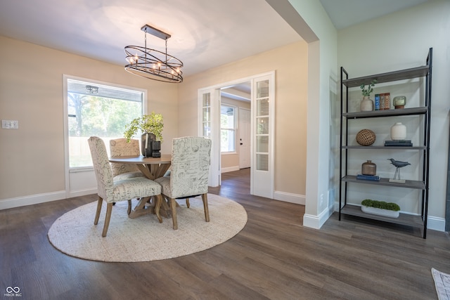 dining space with an inviting chandelier and dark hardwood / wood-style flooring