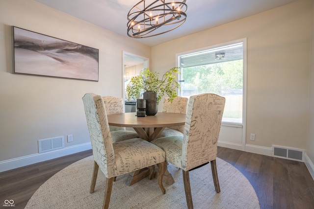 dining area featuring dark wood-type flooring and a chandelier