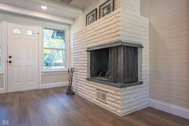 room details with a multi sided fireplace, beamed ceiling, and wood-type flooring