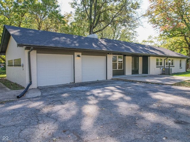 ranch-style house with a garage and central air condition unit