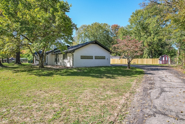 view of property exterior featuring a shed and a lawn