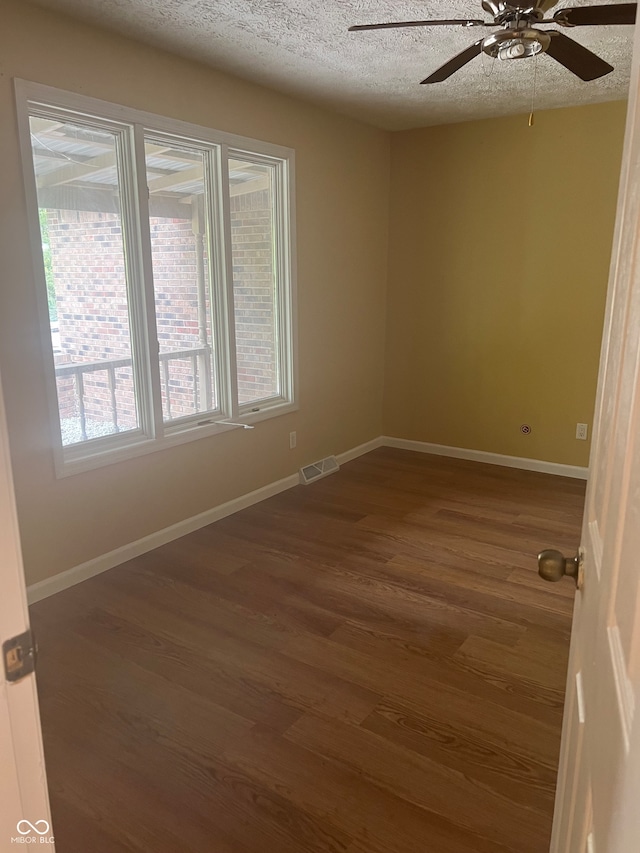 unfurnished room with dark hardwood / wood-style floors, a textured ceiling, and ceiling fan