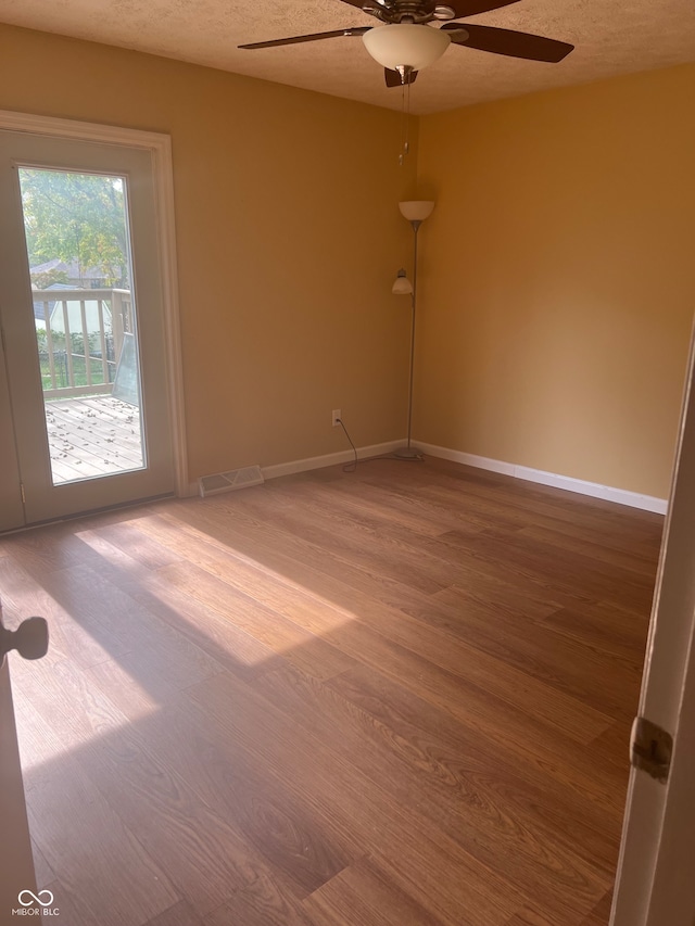 empty room featuring hardwood / wood-style floors, a textured ceiling, and ceiling fan